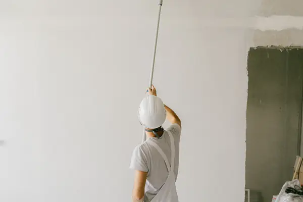 Commercial painter rolling paint onto a ceiling