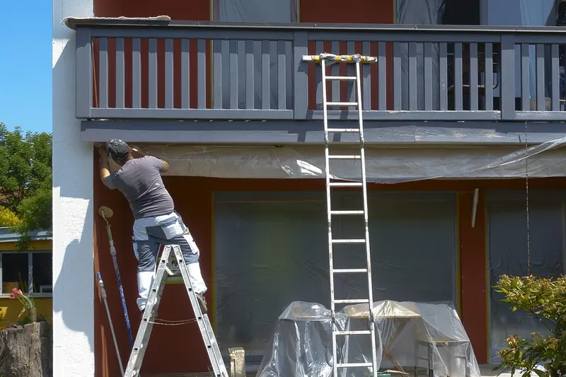 Exterior painting in Abilene: painter on a ladder painting house trim