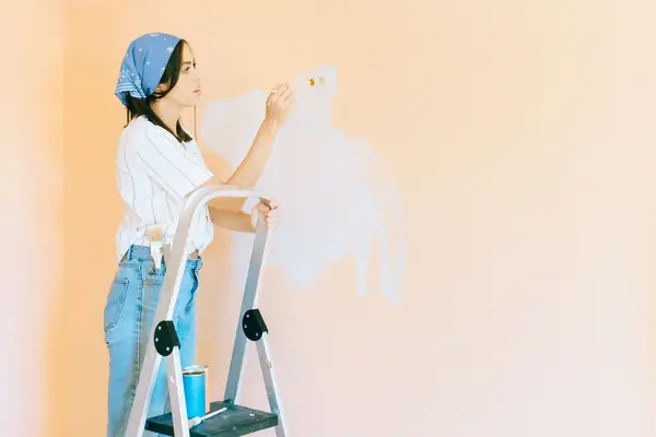 Interior painting in Abilene: painter on a stepladder rolling a wall